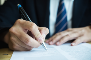 Un homme en costume signe un document