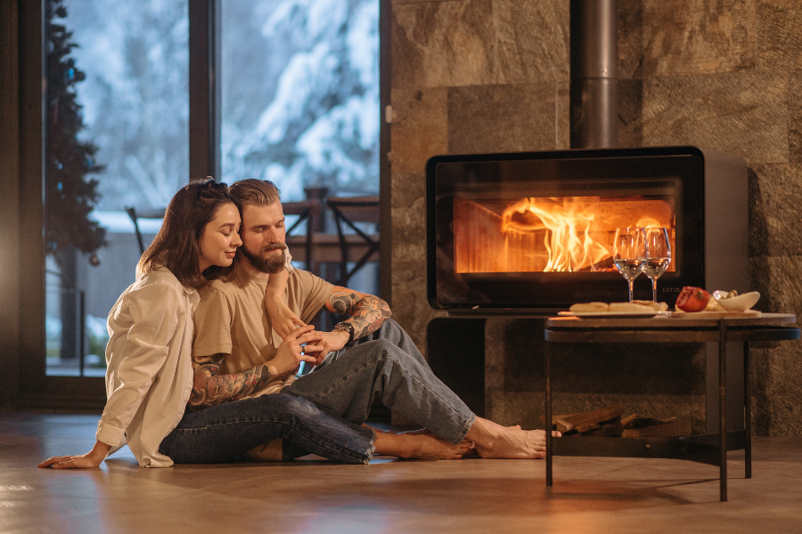 couple de propriétaires devant cheminée en hiver