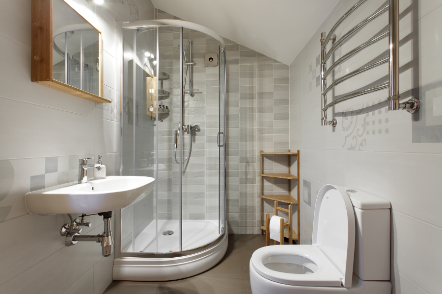 salle de bain avec douche à porte coulissante et toilettes compactes