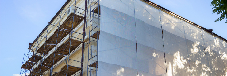 Photo d'échafaudages sur un immeuble représentant des travaux d'isolation de façade pour améliorer les performances énergétiques de l'immeuble