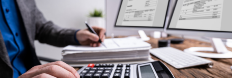 Une personne fait des calculs devant un ordinateur