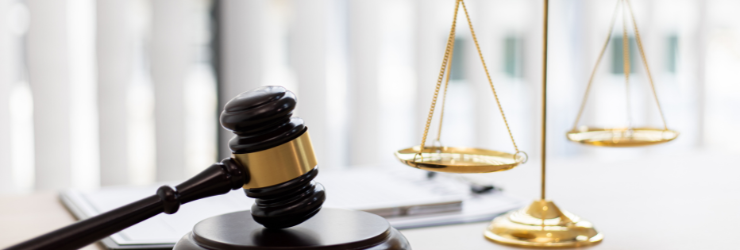Marteau de juge et balance dorée sur un bureau, symbolisant la justice