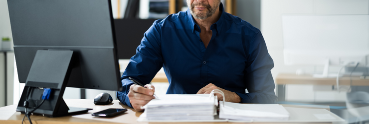 Homme devant un classeur de papiers représentant le président-syndic d'un syndic coopératif